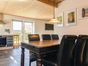 a dining room with a wooden table and leather chairs at 6 person holiday home in Karrebæksminde in Karrebæksminde