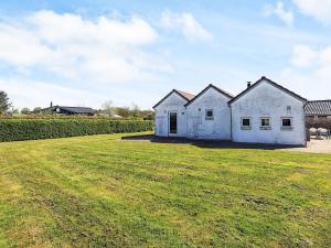 una casa blanca en un campo con césped en 6 person holiday home in Karrebæksminde, en Karrebæksminde