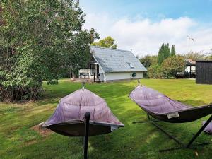 two hammocks in a yard in front of a house at 4 person holiday home in Karrebæksminde-By Traum in Karrebæksminde