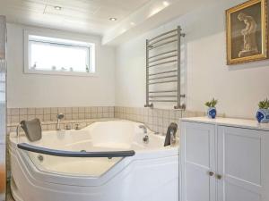 a white bath tub in a bathroom with a window at 14 person holiday home in Rønne-By Traum in Rønne +42 photos