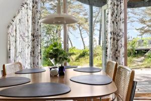 a dining room with a table with chairs and a large window at 3646-Nexo-Frederiksvej-8 in Neksø +13 photos