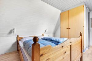 a bedroom with a wooden bed with blue sheets at 3646-Nexo-Frederiksvej-8 in Neksø