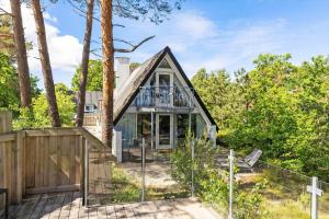 a house in the woods with a fence at 3646-Nexo-Frederiksvej-8 in Neksø