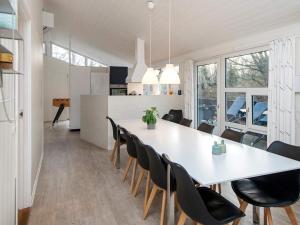 comedor y cocina con mesa blanca y sillas en Luxury Oasis near Grena Strand-By Traum, en Glesborg