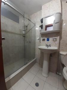 a bathroom with a shower and a sink and a toilet at Hotel Central in Latacunga +60 photos