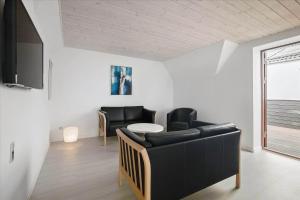 a living room with black chairs and a table at 6797-Allinge-Nordre-Strandvej-127 in Allinge