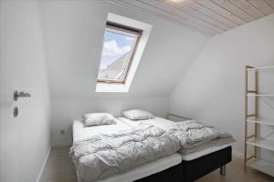 a bed in a white room with a window at 6797-Allinge-Nordre-Strandvej-127 in Allinge