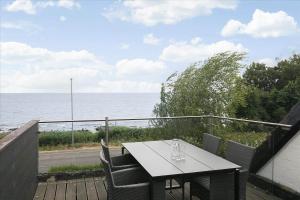 a table and chairs on a balcony with the ocean at 6797-Allinge-Nordre-Strandvej-127 in Allinge