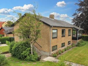een bakstenen huis met een boom in de tuin bij 6-Person Holiday Home in Strandby in Strandby