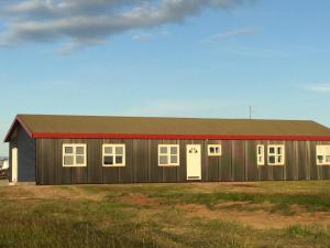 a barn with a red roof and white doors at Lindartún Guesthouse in Lindartún