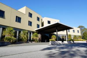 a large building with a black roof at Golden Pebble Hotel in Wantirna