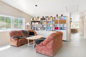 a living room with two chairs and a book shelf at 3627-Nexo-Sandstien-5 in Neksø