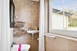 a bathroom with a toilet and a sink and a window at 3627-Nexo-Sandstien-5 in Neksø +17 photos