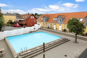 a large swimming pool in a courtyard with houses at 5645-Gudhjem-Broddegade-14-lejl-13 in Gudhjem +13 photos