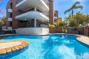 a swimming pool in front of a building at Surfrider - Beach front apartment with pool in Byron Bay