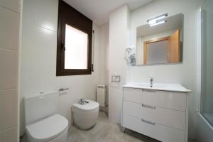 a bathroom with a toilet and a sink and a mirror at Kisa Apartments de Manresa in Manresa
