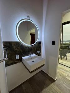 a bathroom with a white sink and a mirror at EL PALMAR in Villa Carlos Paz +22 photos