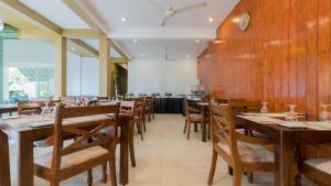 a dining room with wooden tables and chairs at Waves Hostel in Negombo