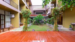 an empty courtyard of a building with trees and benches at Waves Hostel in Negombo