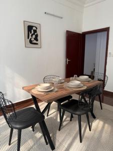 a dining room table with black chairs and a wooden table at Satya in Motsouémbé +8 photos