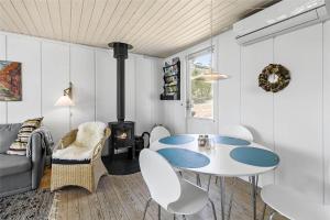 a living room with a table and a stove at 5506-Gudhjem-Gudhjemvej-111-N in Gudhjem +13 photos