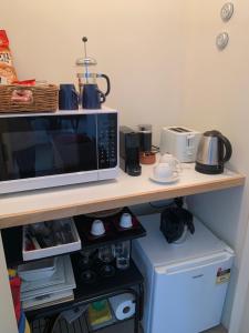 a microwave sitting on a counter next to a refrigerator at Puka Heights in Pauanui