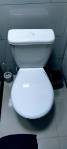a white toilet in a bathroom with the lid down at Pousada Santa Maria in Canoinhas