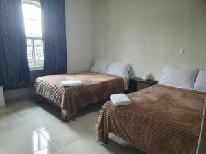 a hotel room with two beds and a window at Hotel Mi Casa Mata II in Morelia +22 photos