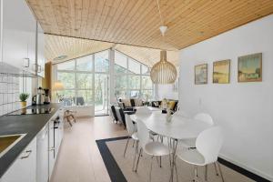 een keuken en eetkamer met een witte tafel en stoelen bij 1502-Aakirkeby-Malurtvej-7 in Vester Sømarken