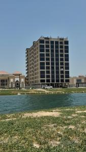 a tall building in front of a body of water at The coze spot in Ath Thuqbah