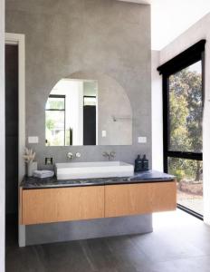 Un baño con una bañera grande y un espejo grande. en Nativ Escape - A luxurious retreat in Margaret River, en Margaret River Town