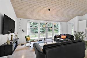ein Wohnzimmer mit zwei Sofas und einem Fernseher in der Unterkunft 1435 Aakirkeby - Ædjavejen 10 in Vester Sømarken