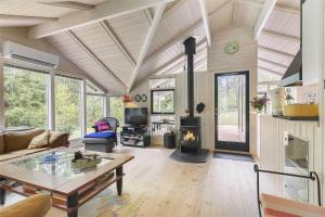 ein Wohnzimmer mit Tisch und Kamin in der Unterkunft 2681 Nexø - Munkegårdsskoven 26 in Neksø