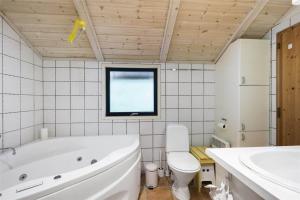 ein Badezimmer mit Badewanne, Toilette und Waschbecken in der Unterkunft 2681 Nexø - Munkegårdsskoven 26 in Neksø