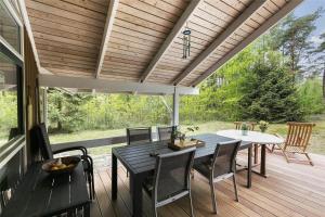 eine Terrasse mit Tisch und Stühlen auf einem Deck in der Unterkunft 2681 Nexø - Munkegårdsskoven 26 in Neksø + 13 Fotos