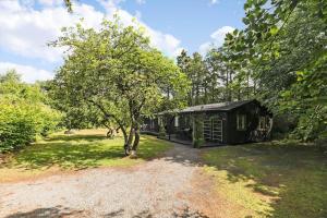 a cabin in the middle of a yard with a tree at 6510-Hasle-Toftegardsvej-34-B in Hasle