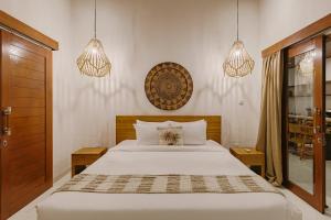 a bedroom with a bed and two pendant lights at Arizona Villa by Betterplace in Cemagi