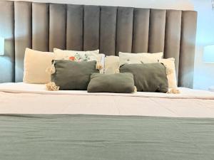 a bed with a bunch of pillows on it at Bolongo 3BR your exclusive oceanfront escape in Punta Mita