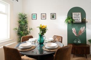 a dining room with a table with plates and flowers at Amica Rose in Belfast