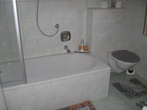 uma casa de banho com uma banheira branca e um WC. em Gästehaus Renate em Biberwier