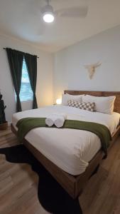 ein Schlafzimmer mit einem großen Bett mit zwei Handtüchern darauf in der Unterkunft Oak and Agave House - Downtown New Braunfels Retreat in New Braunfels