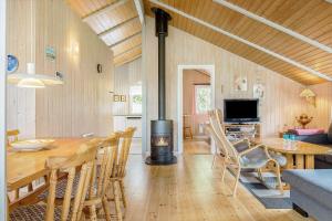 ein Wohnzimmer mit einem Esstisch und einem Kamin in der Unterkunft 1412 Aakirkeby - Boesparken 12 in Vester Sømarken