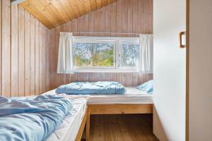 ein Schlafzimmer mit zwei Betten und einem Fenster in der Unterkunft 1412 Aakirkeby - Boesparken 12 in Vester Sømarken