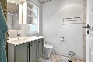 a bathroom with a sink and a toilet and a window at 2531-Nexo-Pilegardsvejen-29 in Neksø +12 photos