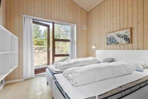 una camera da letto con un letto con lenzuola bianche e una finestra di 6662-Allinge-Tejnvej-65 ad Allinge