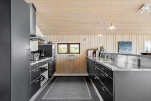 una cucina con mobili neri e un piano di lavoro di 6662-Allinge-Tejnvej-65 ad Allinge