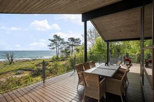 una terrazza in legno con tavolo e sedie sulla spiaggia di 6662-Allinge-Tejnvej-65 ad Allinge