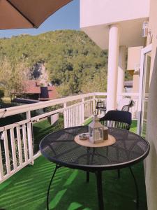 a table and chair on a balcony with a view at Layal Home in Bihać