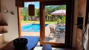 a door leading to a patio with a table and a pool at Casa Canto do Bem-te-vi in Lençóis +60 photos