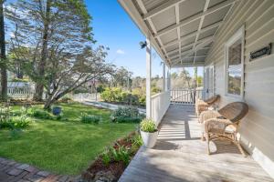 a porch with wicker chairs on a house at Inchcolm in Leura